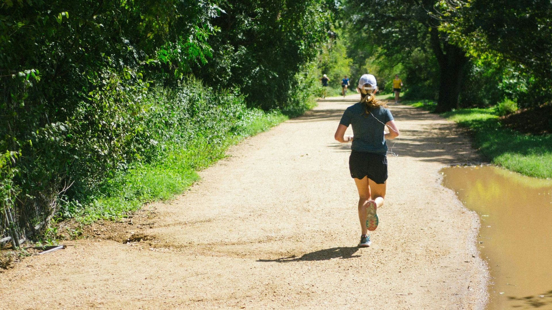 Woman running on a trail in the sunshine