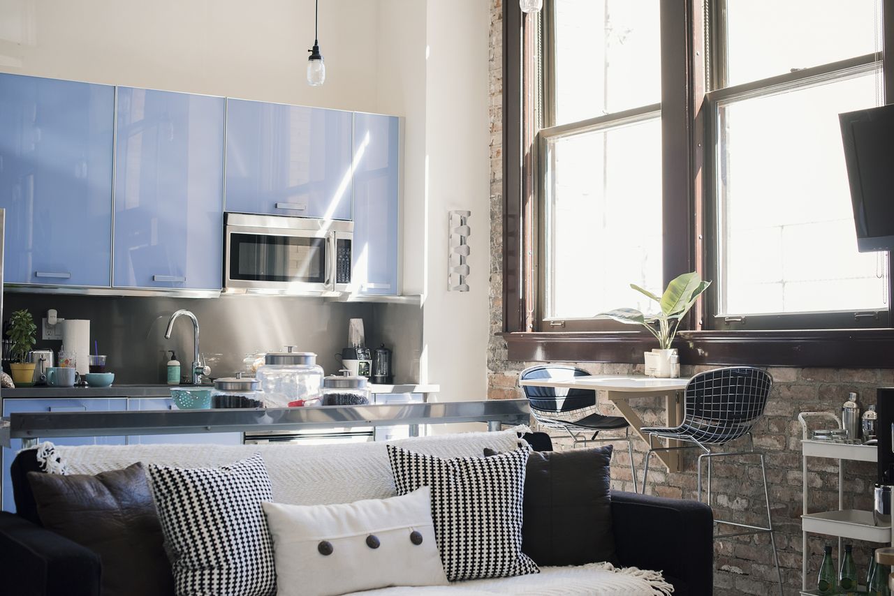 Kitchen with blue cabinetry behind sofa