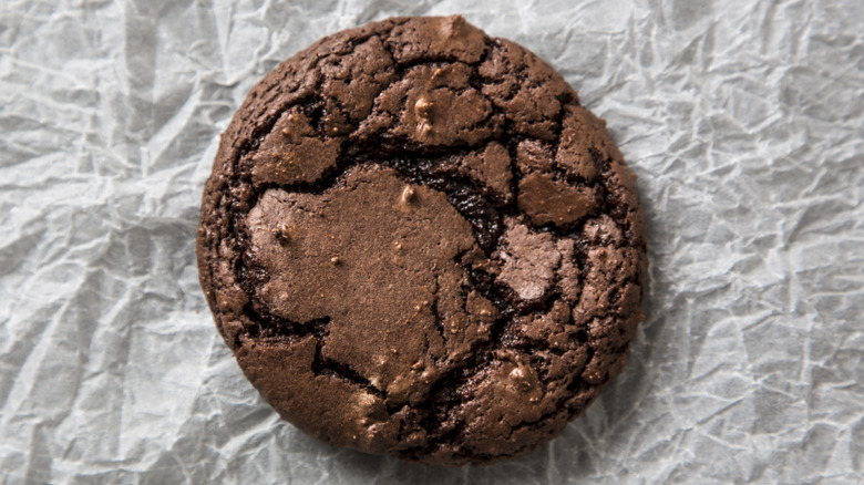 Brownie batter cookie against crinkled white paper background