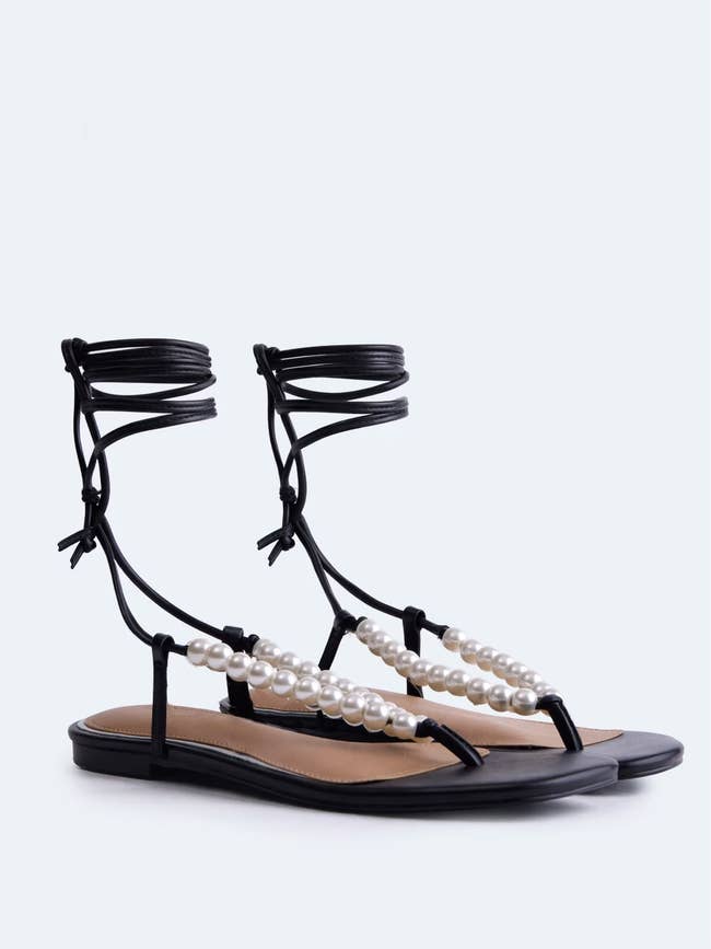 Elegant flat sandals with pearl-like bead straps and ankle ties, featuring a minimalist design. Perfect for stylish summer occasions