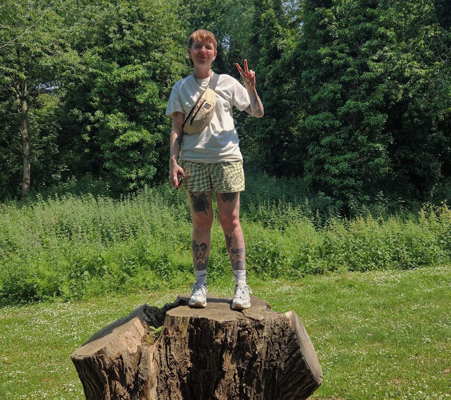 Dee Whitnell standing on a tree trunk in the countryside