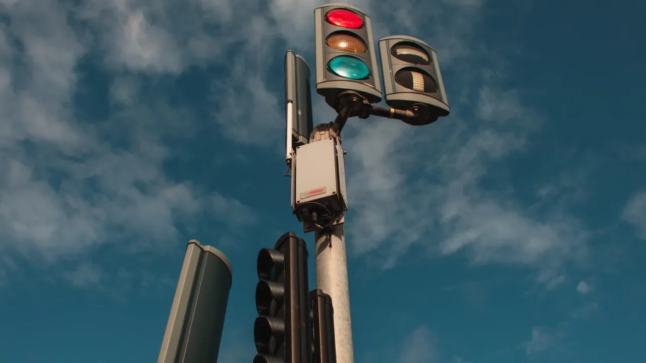 Low angle view of traffic lights with cloudy sky.