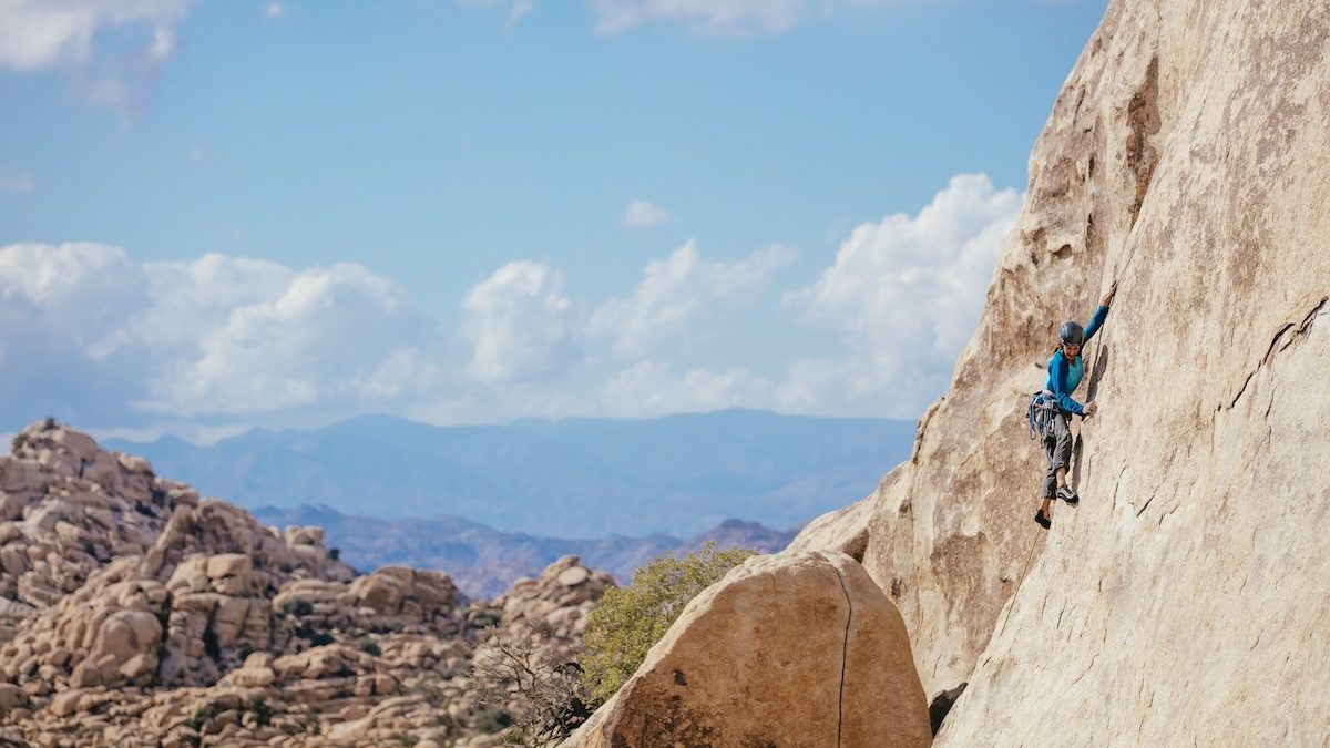a person rockclimbing at Joshua Tree National Park in California on a sunny day