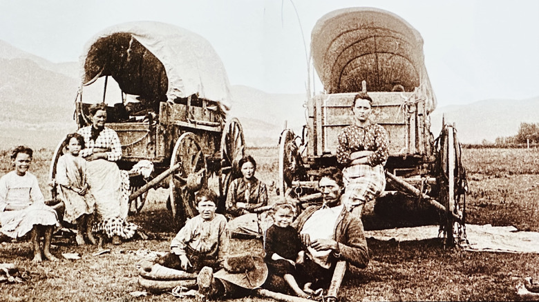 Old photo of people with 19th century wagons