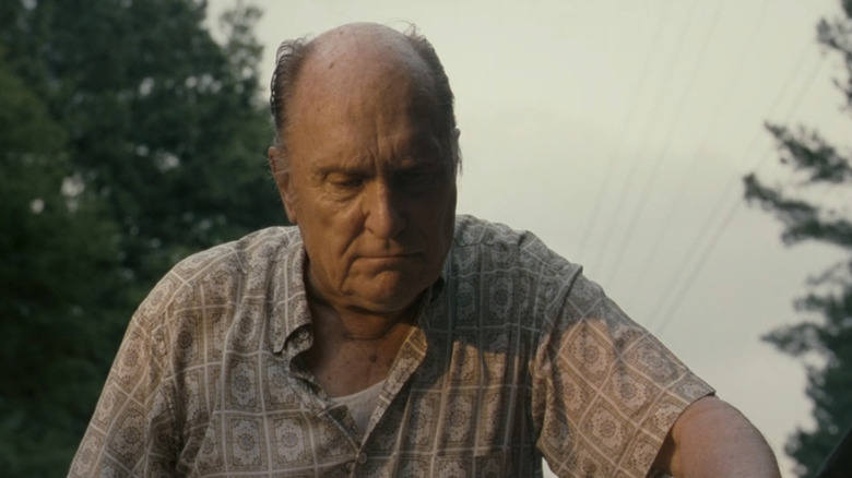 Robert Duvall's Jim Caldwell looks down as he stands outside in Jayne Mansfield's Car