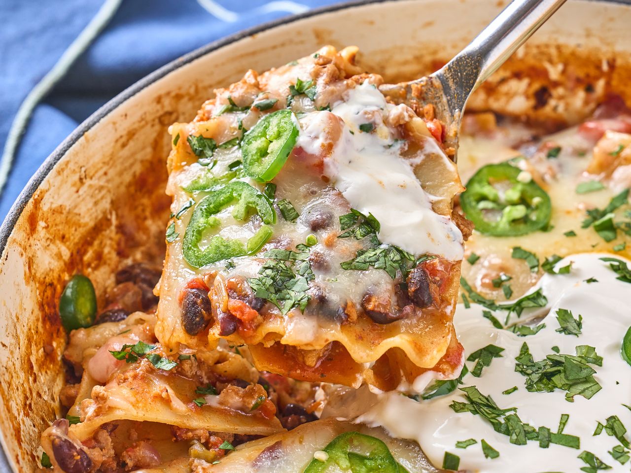 A skillet lasagna dish with a serving lifted out
