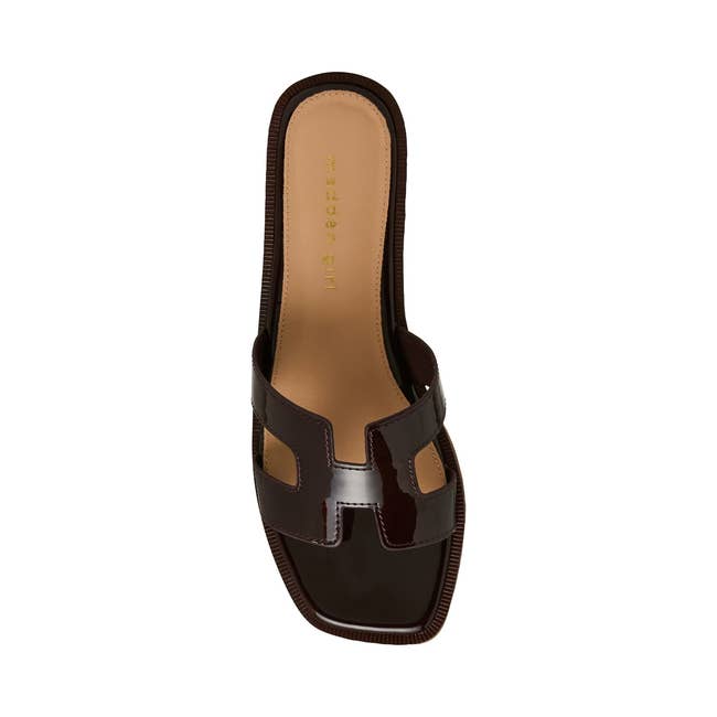 Stylish slide sandal with cut-out design and glossy finish, perfect for modern fashion looks