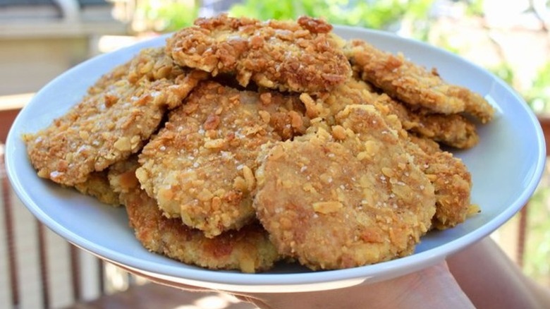 A blue plate piled with saltine-crusted pork tenderloin