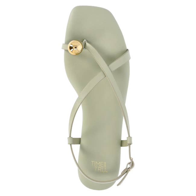 Strappy sandal with a circular gold accent and thin straps, perfect for summer wear