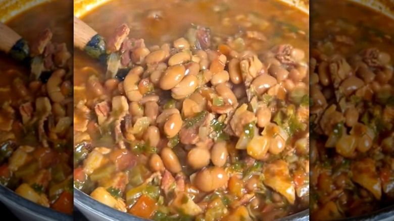 A big pot of frijoles charros, or cowboy beans, with meat, onions, tomatoes, and jalapeños