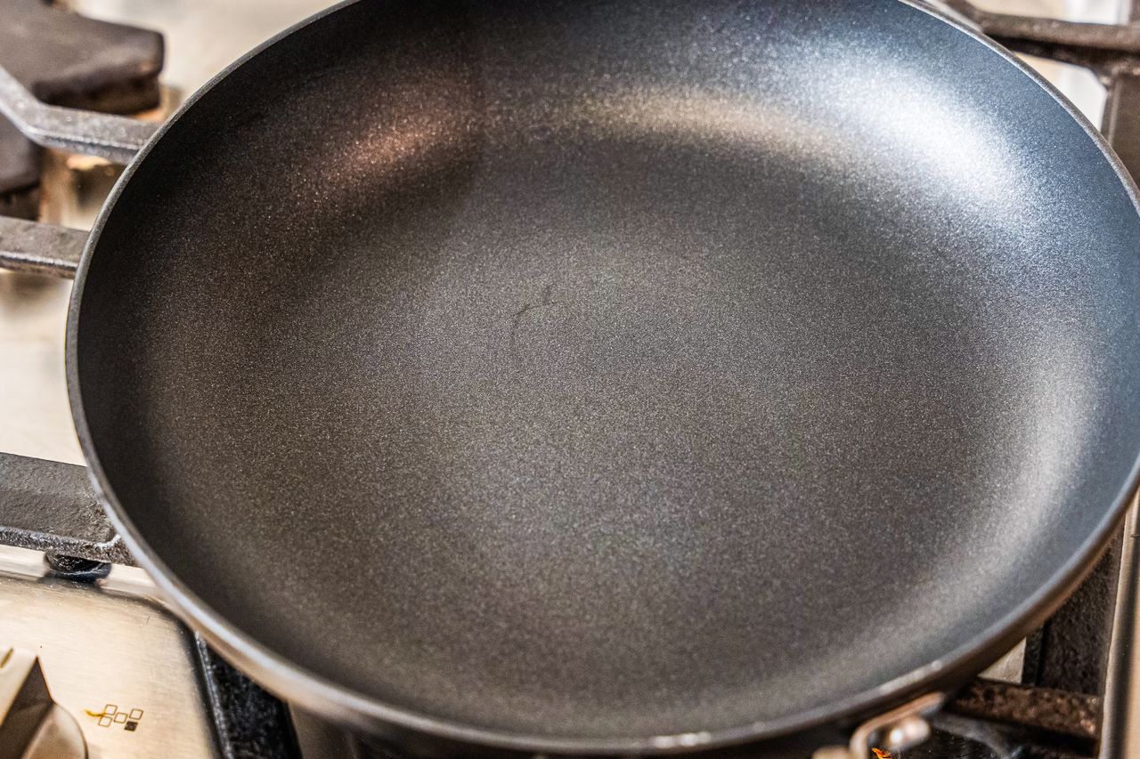 A black nonstick pan on a gas stovetop