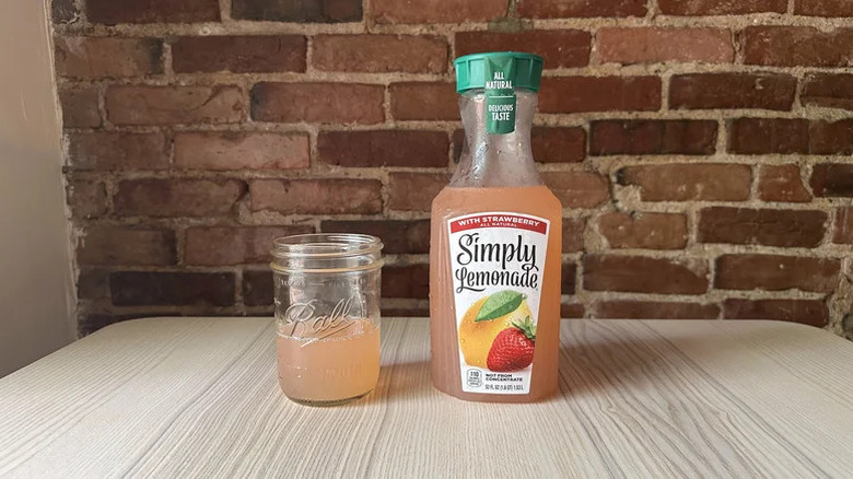 Bottle of Simply Lemonade with Strawberry next to full glass