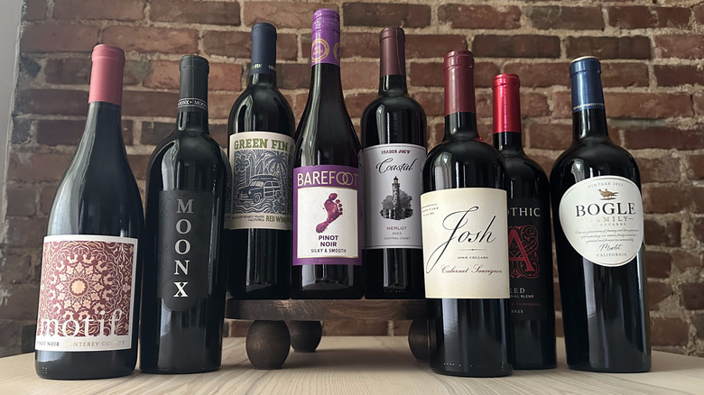 Bottles of value red wine on wooden table