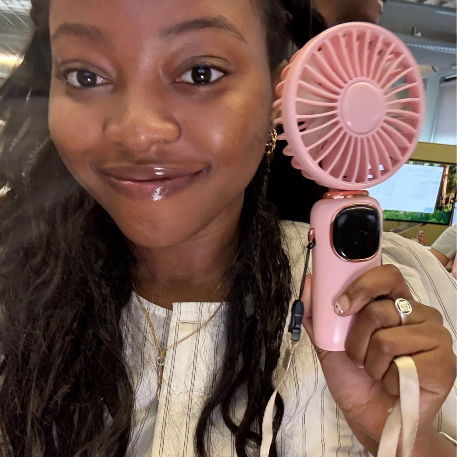Woman holding pink handheld fan. (Courtesy Jem Alabi)