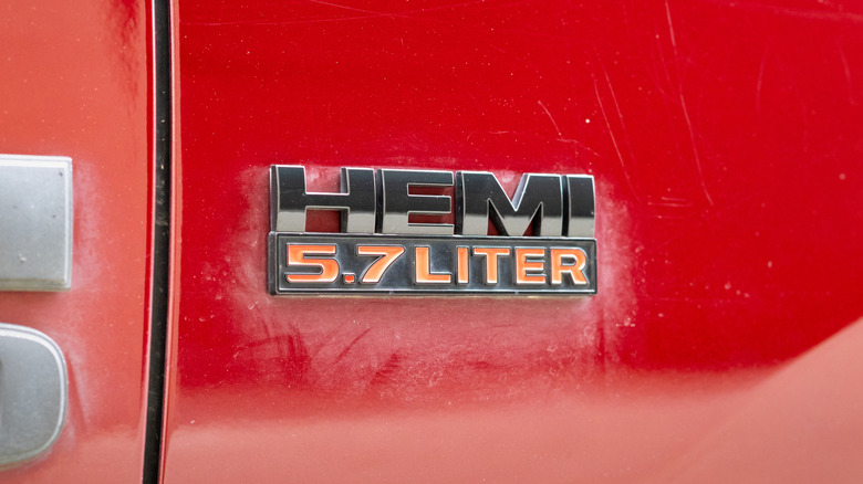 A Hemi 5.7 liter badge on a red Dodge Ram pickup truck.
