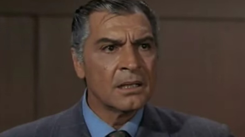 Bela Okmyx, a human-seeming alien wearing a suit, looks surprised on Star Trek: The Original Series