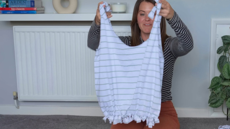 Woman holding up a bag made from a striped T-shirt