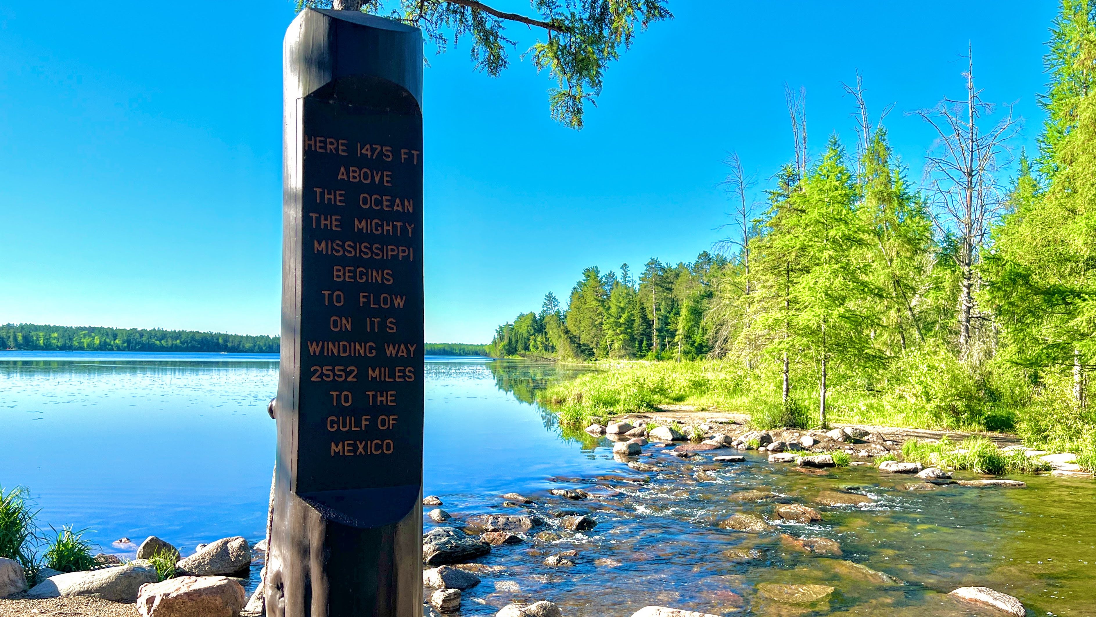 A marker stands at the headwaters of the Mississippi River, where it begins as a small stream flowing out of Lake Itasca in northern Minnesota.