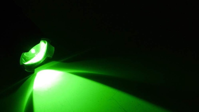 A flashlight emitting a green light in the dark