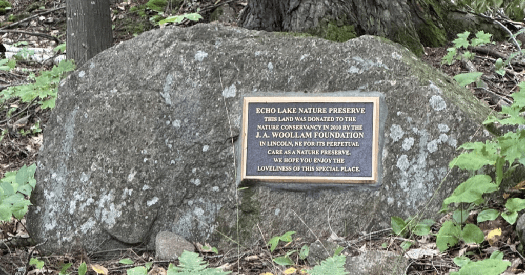 Commemorative plaque on a rock boulder at Echo Lake Nature Preserve entry in Michigan.