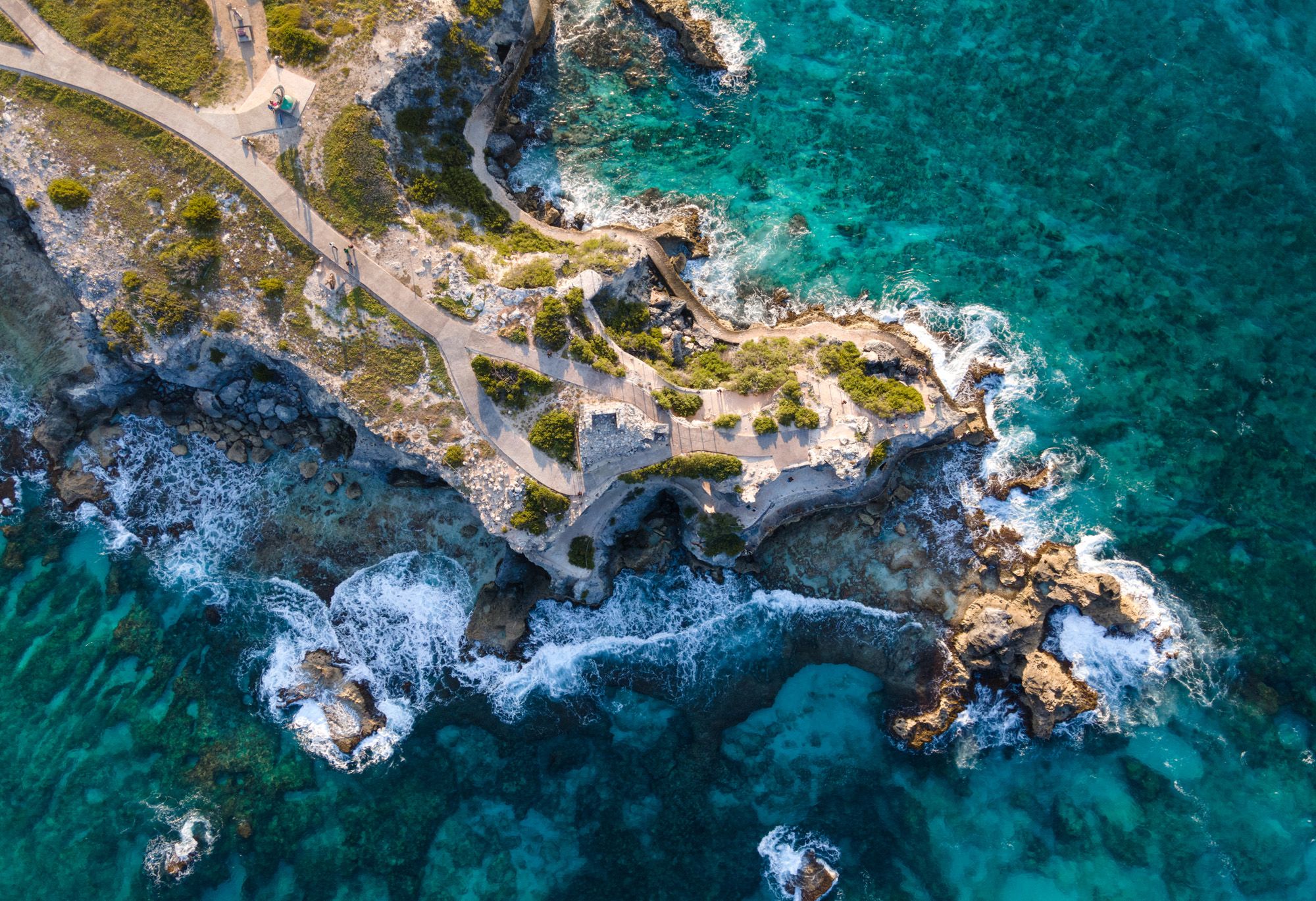 Turquoise waters lap onto jagged rocks on Isla Mujeres