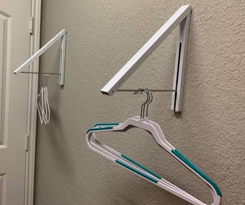 reviewer photo of the arms of the rack pulled down and several empty hangers hanging from them