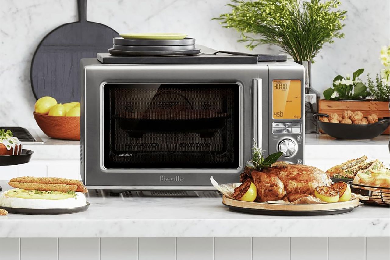 A Breville combination microwave displayed with various food items in a kitchen setting
