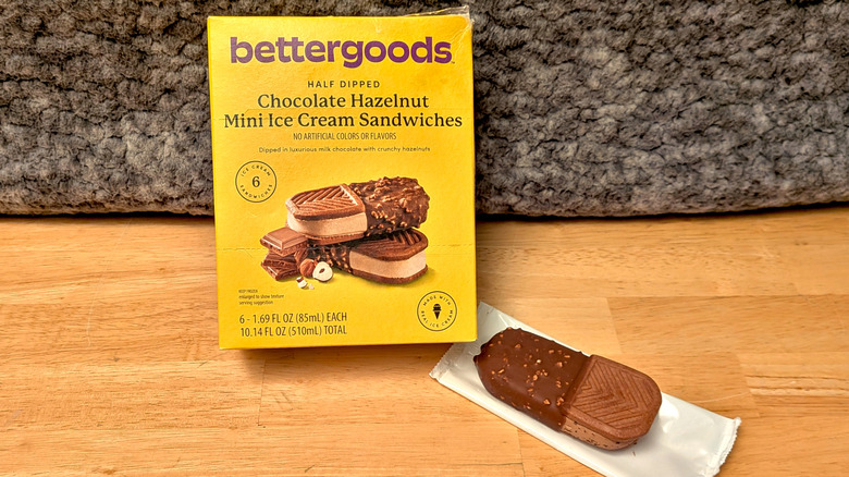 A box of Walmart's Bettergoods brand Chocolate Hazelnut Mini Ice Cream Sandwiches beside an unwrapped ice cream sandwich