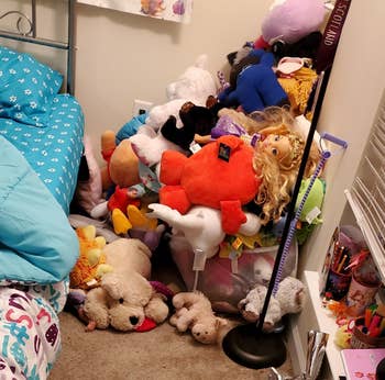 corner of a room with a large pile of stuffed animals