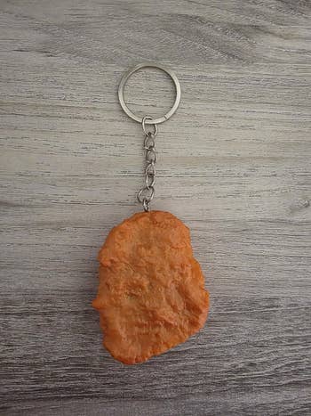 Chicken nugget-shaped keychain on a wooden surface