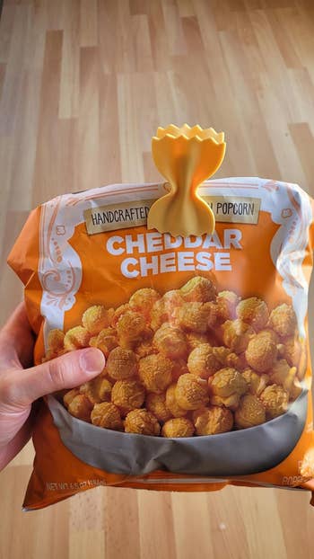 Hand holding a bag of handcrafted popcorn labeled