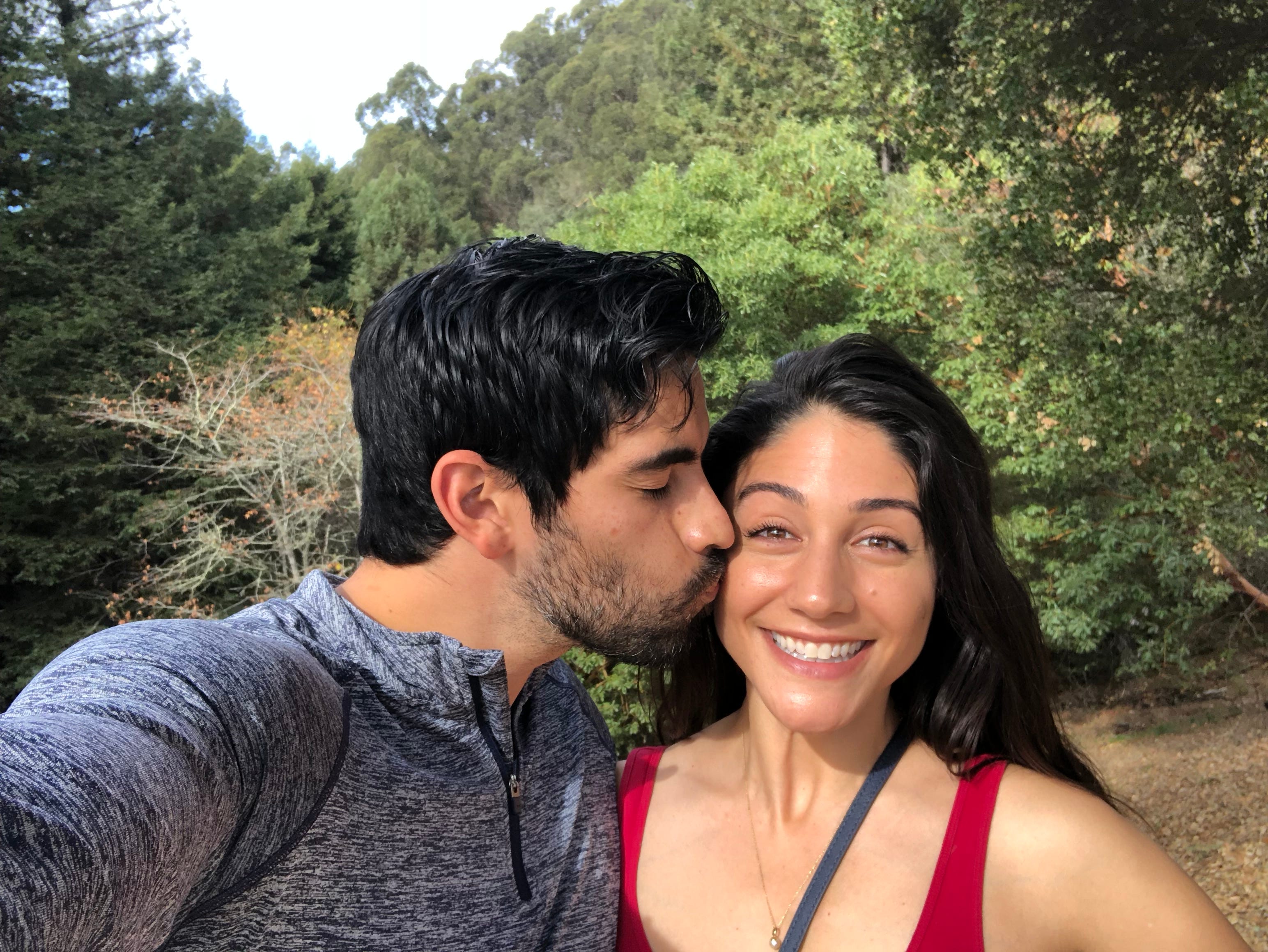 The author gets a kiss from her husband while on a path outside.