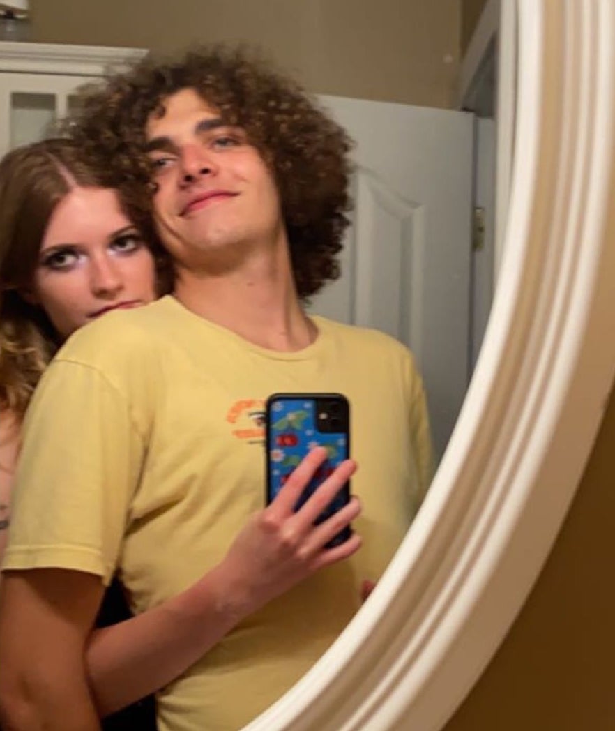 Me taking a mirror selfie of me hugging Eddie from behind as he smiles