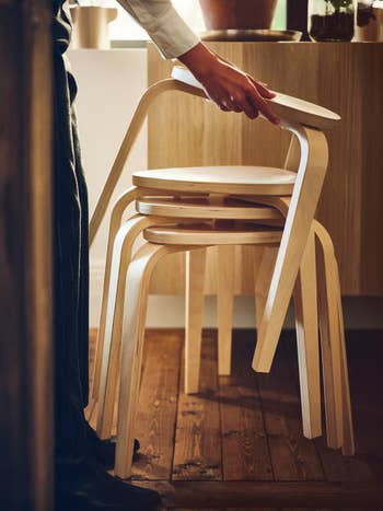 hands stacking four birch stools