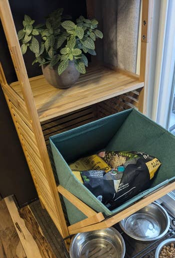 hamper tilted out to show removable basket and dog food stored inside