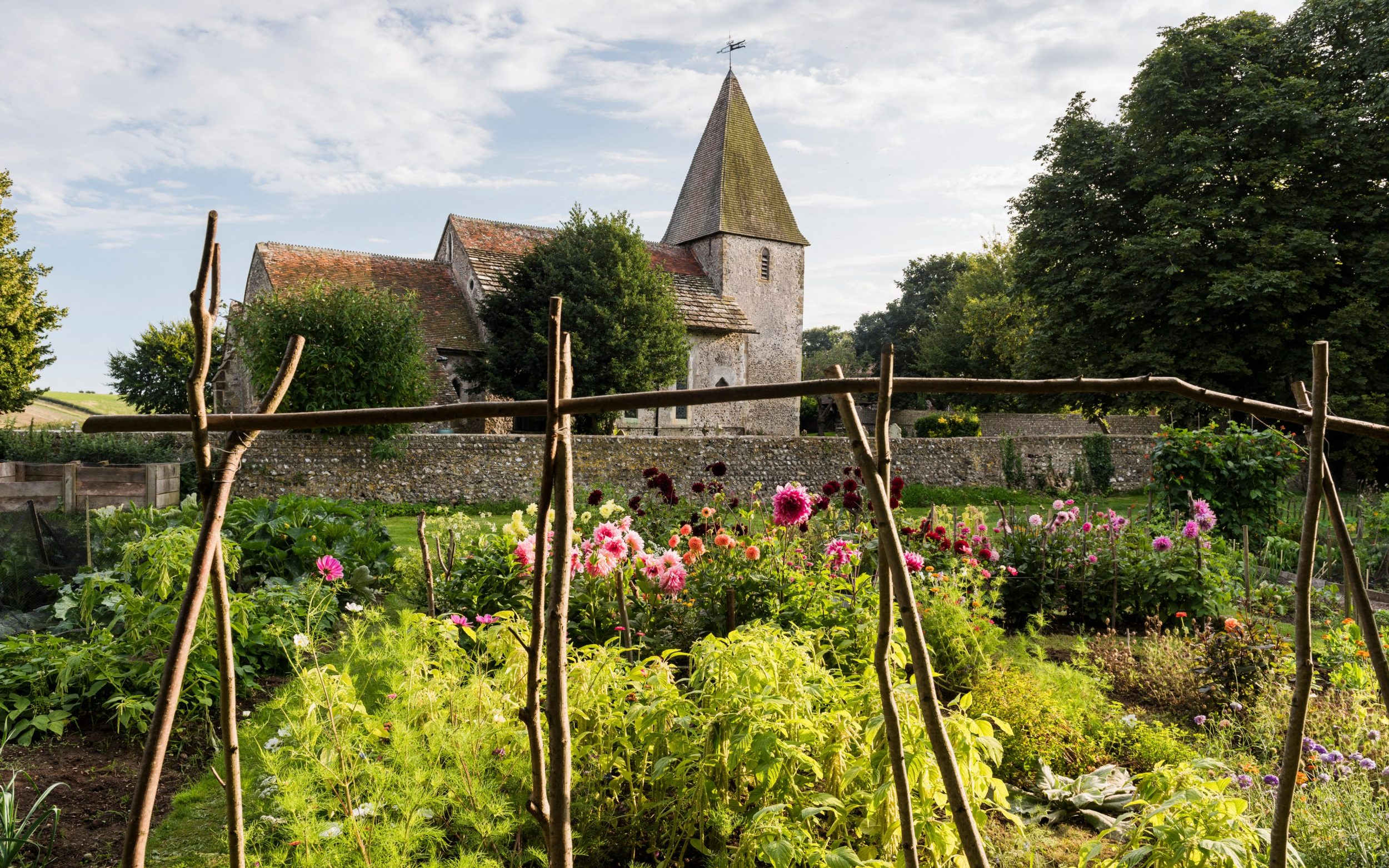 Garden view of 12th century church from cottage, once home to Virgina Woolf