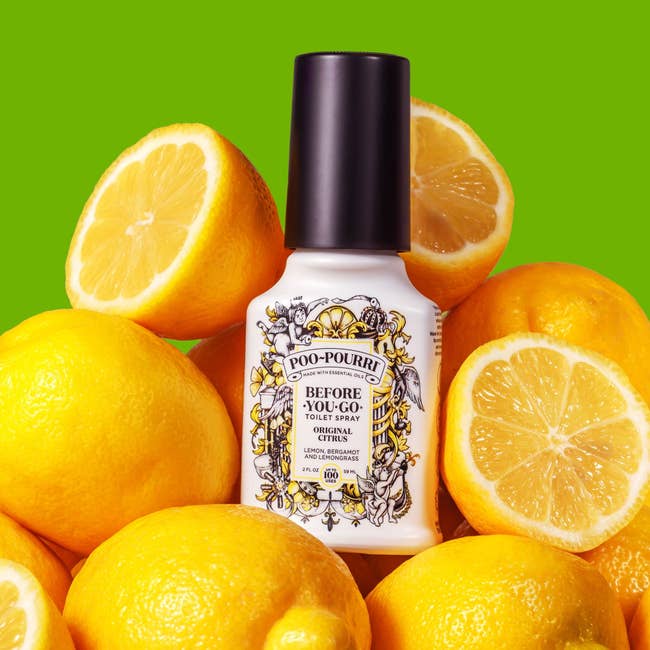 Poo-Pourri toilet spray bottle surrounded by lemons, on a green background