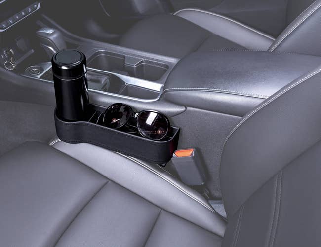 Car cup holder organizer on center console, holding a thermos and sunglasses, showcasing efficient use of vehicle space for shopping article