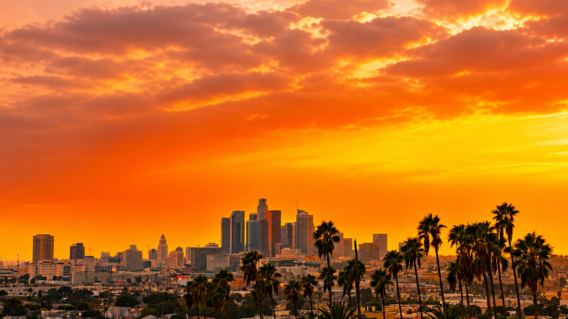 Los Angeles skyline beneath a fiery sunset