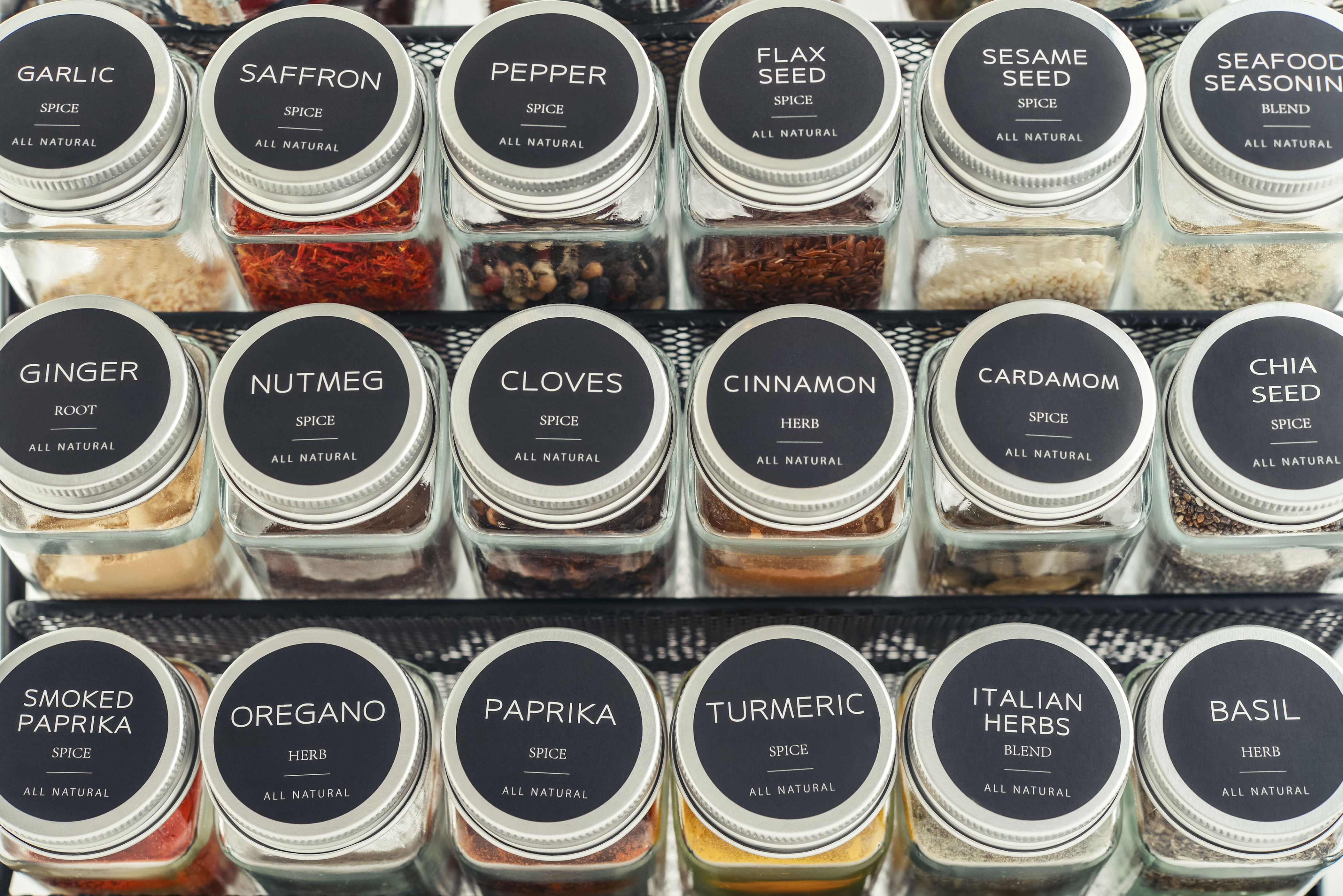 Various glass jars with labeled lids contain spices and herbs