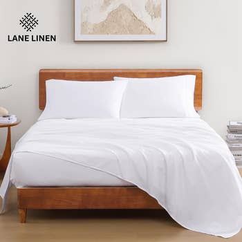 A neatly made bed with white bedding