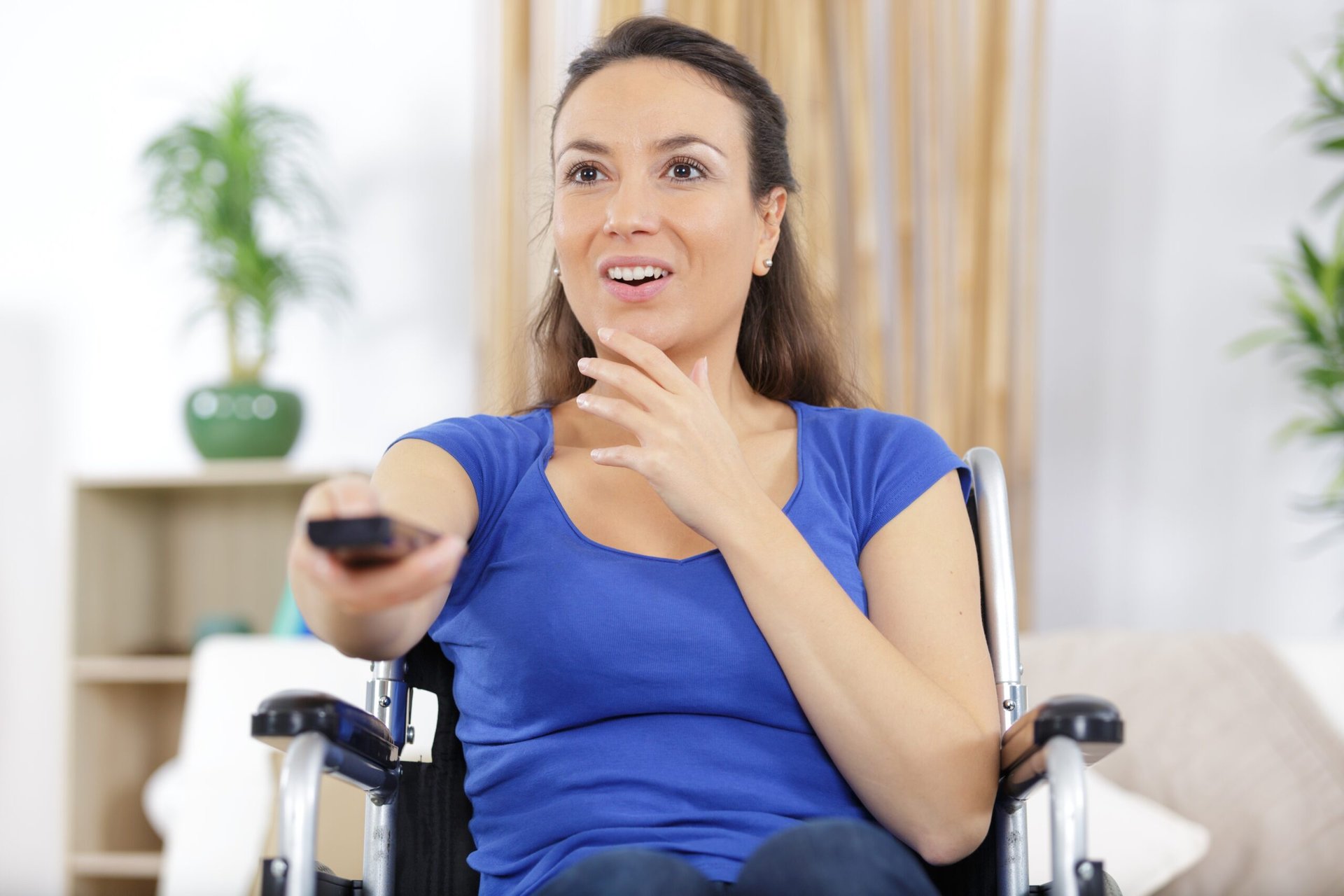 woman in wheelchair having fun while watching tv