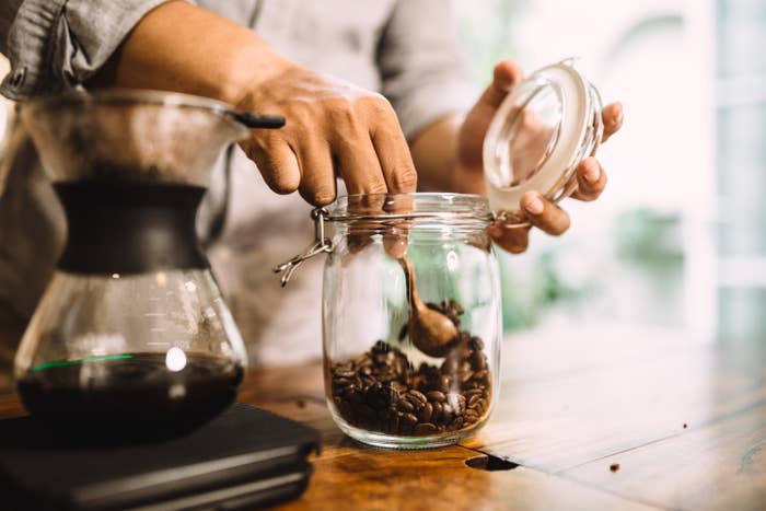 A person scooping coffee beans
