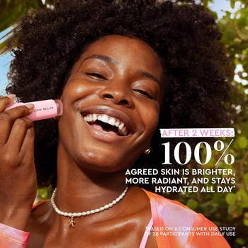 Person smiling while applying transparent stick on face