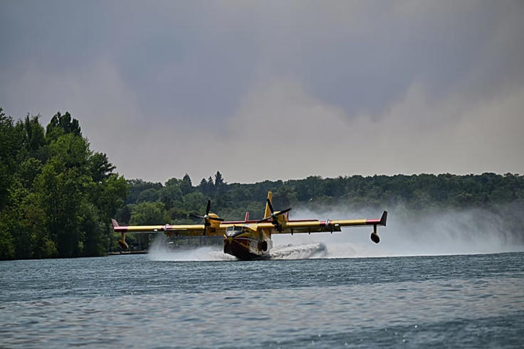 A Canadair water bomber scoops up water from the Seine River while fighting wildfires in the Fontainebleau forest region, France, Monday, July 13, 2026. AP Photo/Emma Da Silva