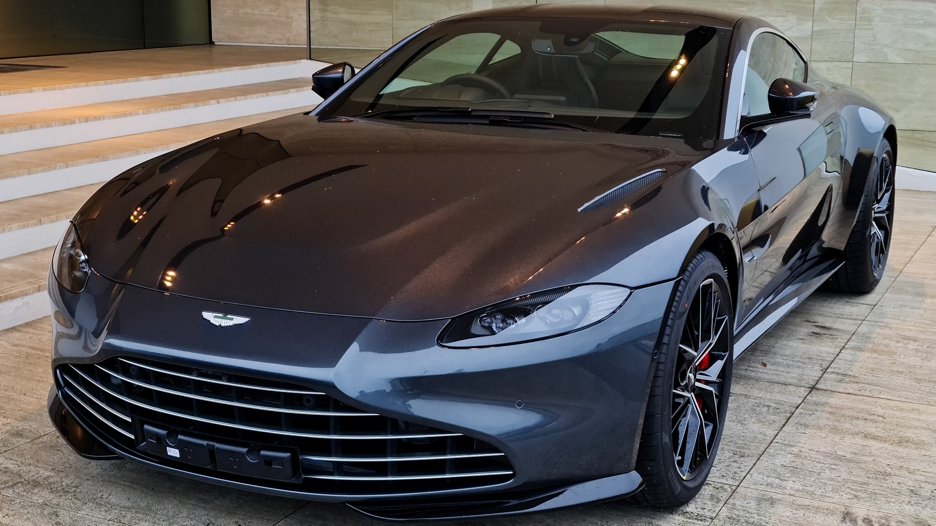 Discover a black 2020 Aston Martin Vantage V8 with new optional grille, displayed in a showroom