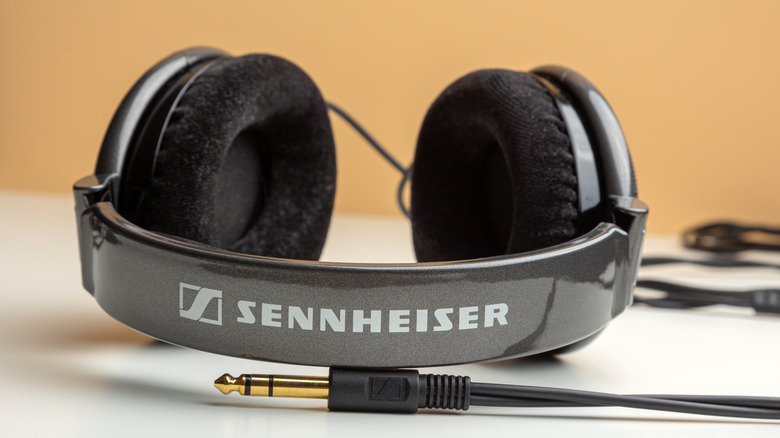 A pair of wired Sennheiser headphones on a flat surface.
