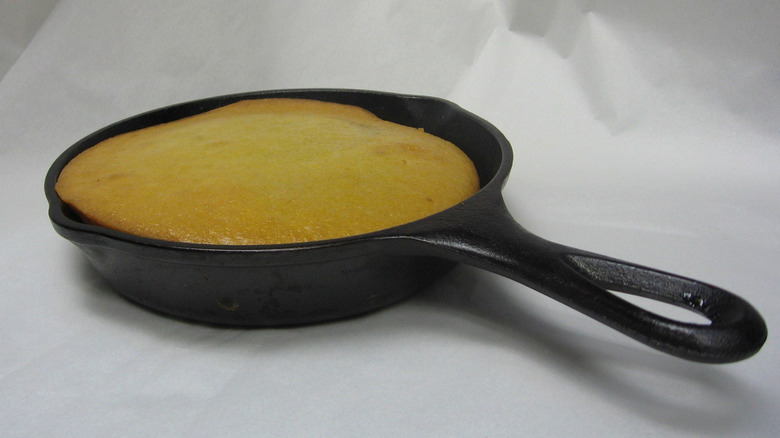 A cast iron skillet with cornbread in it.