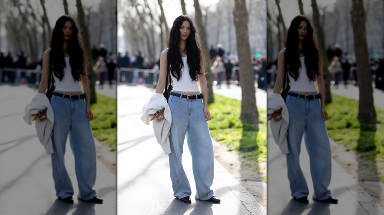A woman in baggy jeans and a tank