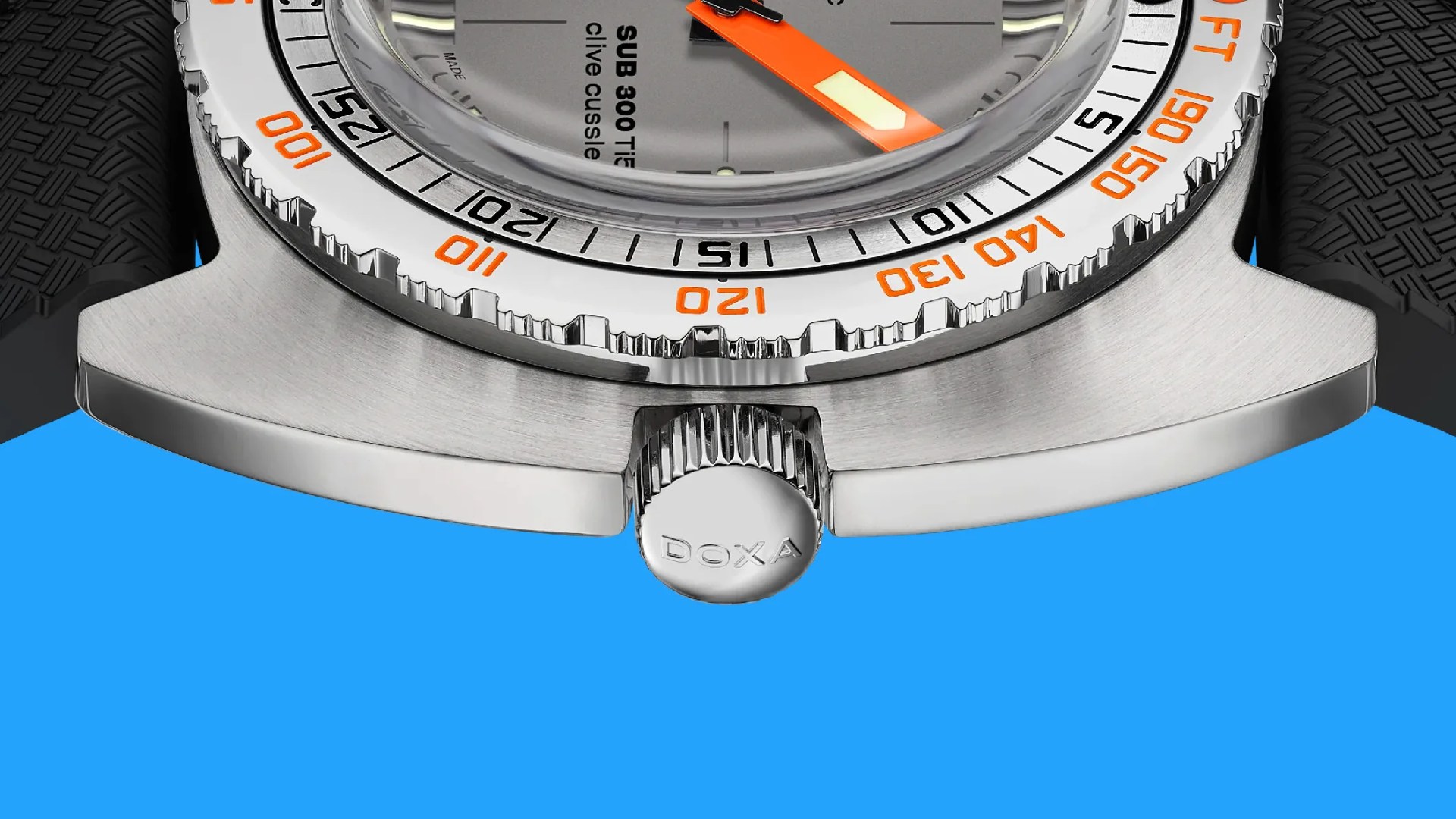 Close-up of a stainless steel watch case with a knurled crown engraved with 